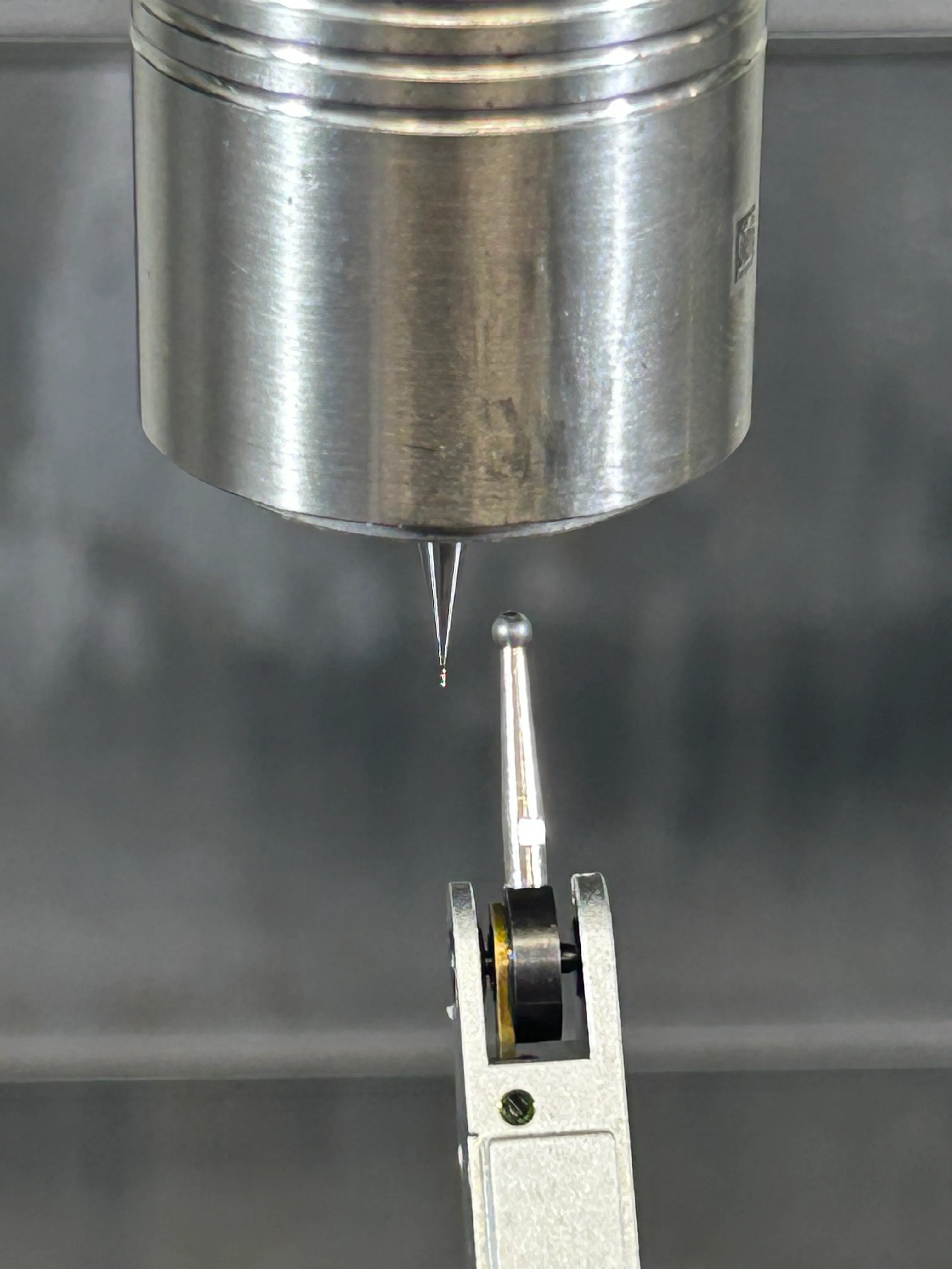 Close-up of a 0.010-inch end mill measured against a precision dial indicator on the CNC spindle