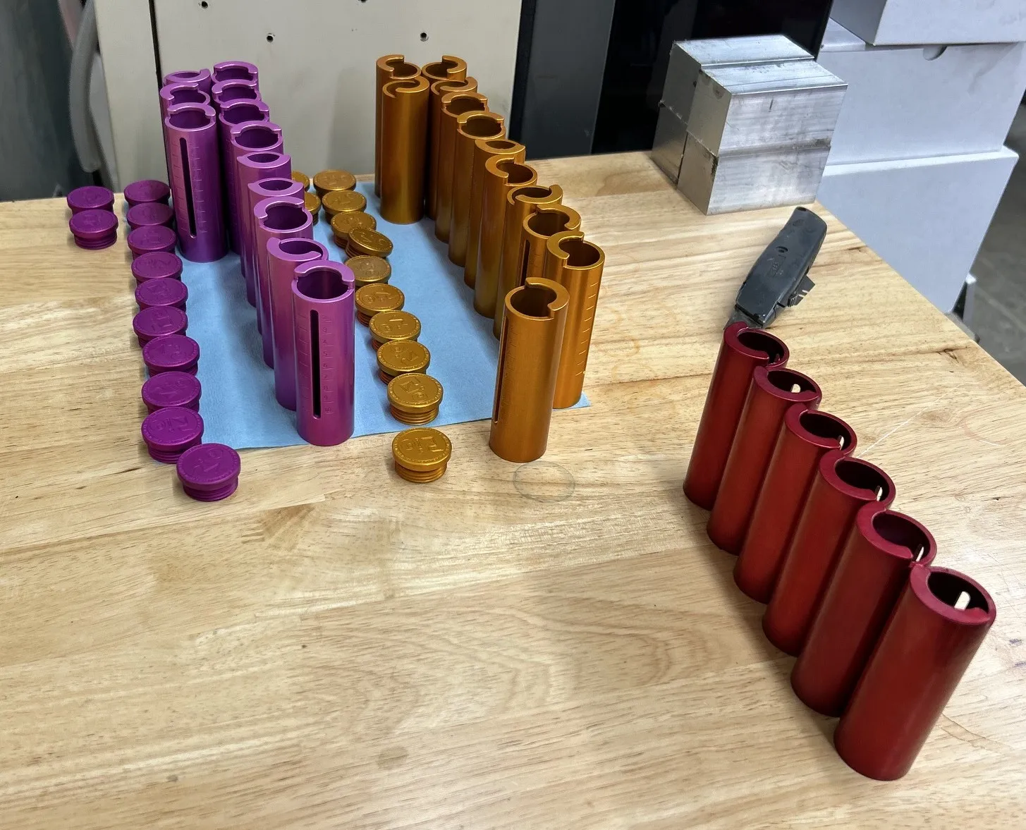 Batches of colorful Type III anodized aluminum coin holders in purple, gold, and red