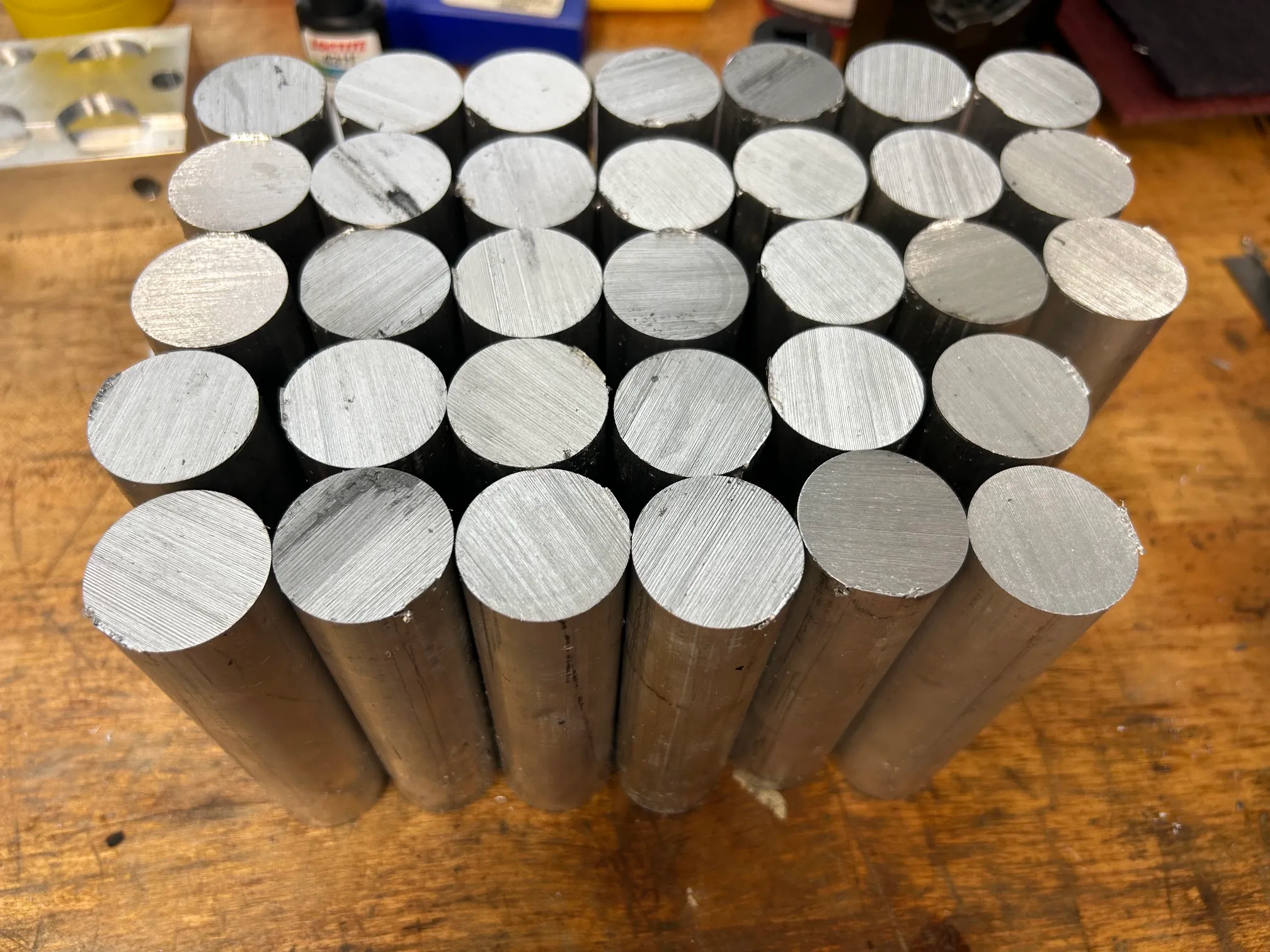 Bundle of round aluminum and steel bar stock stood on end, ready for machining