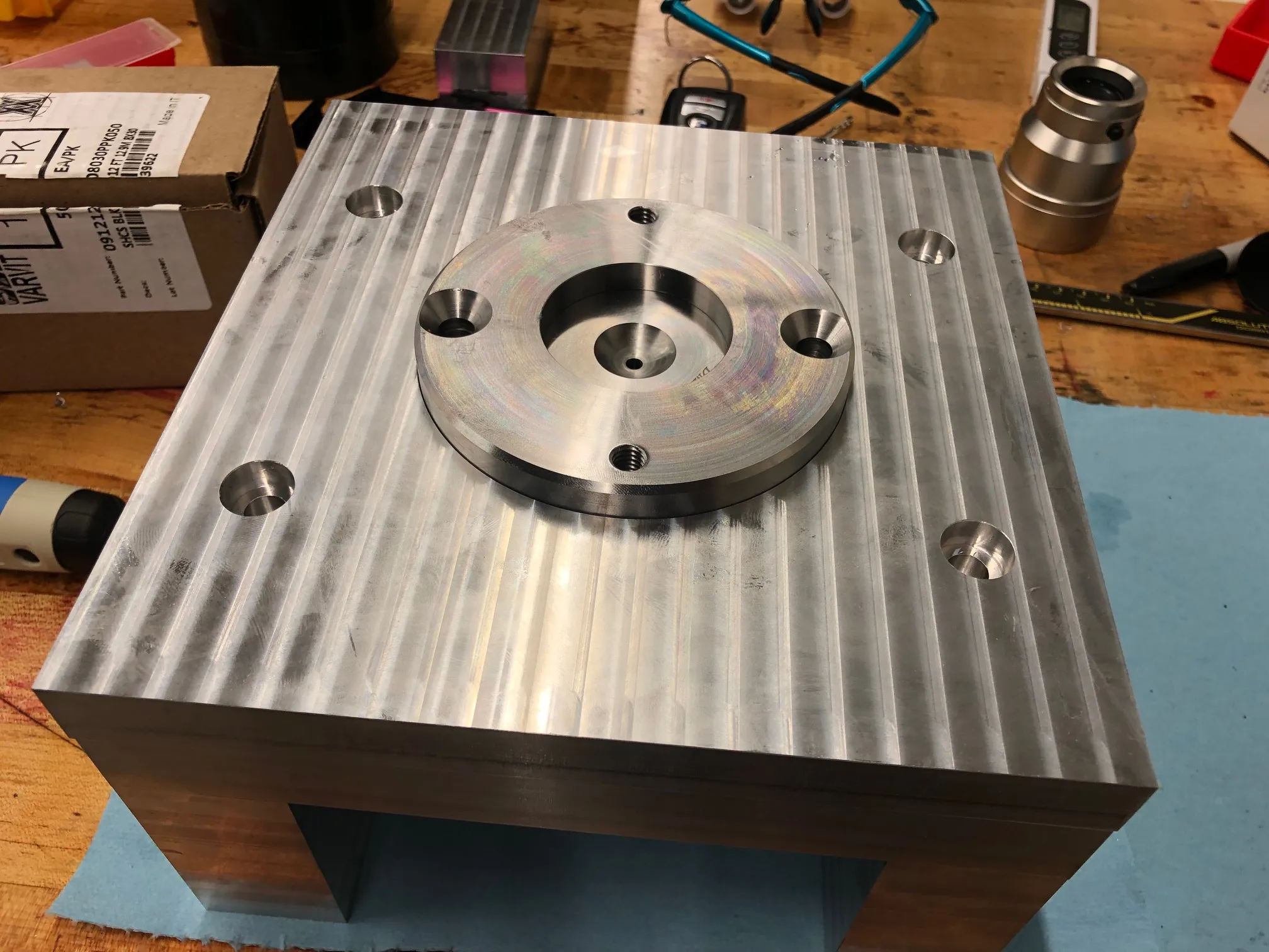 Precision-machined steel mold base with a flanged center bore and counterbored mounting holes